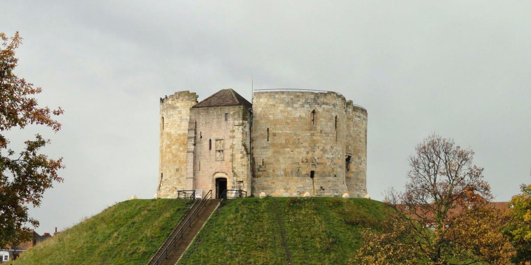 Clifford’s Tower in York, a historic stone keep atop a grassy motte. Once part of York Castle, it played a key role in medieval conflicts and offers panoramic city views today.