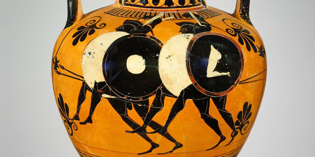 Ancient Greek terracotta amphora features black-figure artwork depicting four hoplites running in formation, carrying large shields and spears, possibly representing a battle or athletic contest.