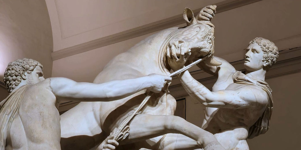 Dramatic marble sculpture of two muscular men struggling to control a rearing bull, showcasing intense motion and detailed anatomy.