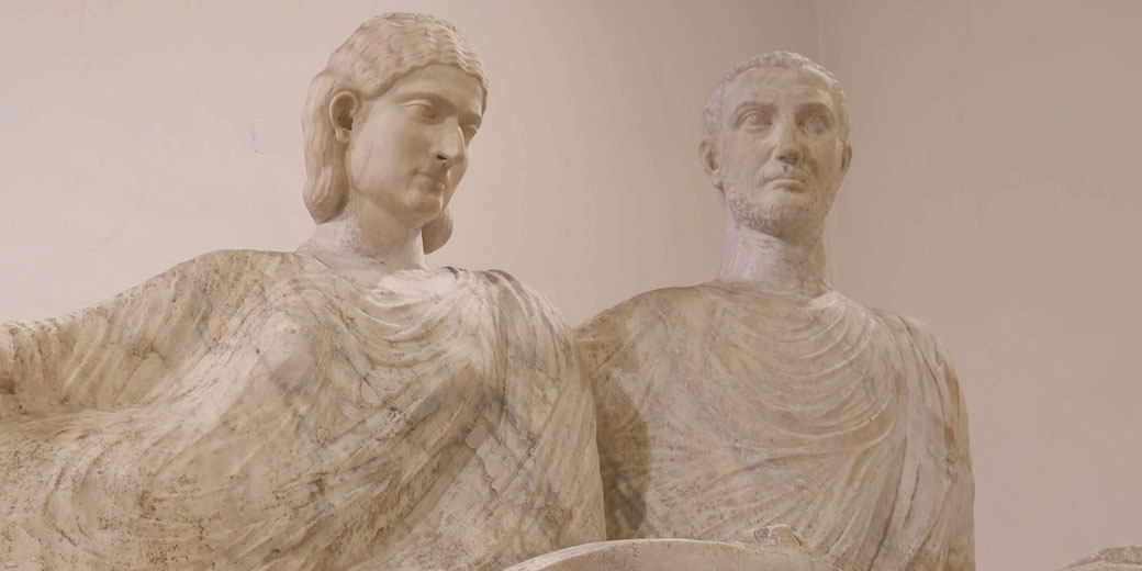 Marble statues of a Roman couple standing side by side, both wearing draped garments, with serene and composed expressions.