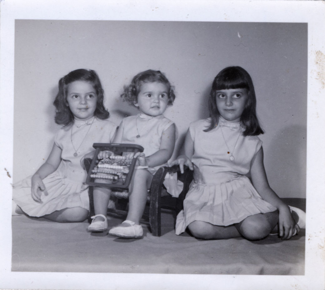 Mis hermanas y yo, vestidas iguales, es una foto en un estudio fotográfico, firmada con lápiz. No llego a identificar el nombre del fotógrafo.