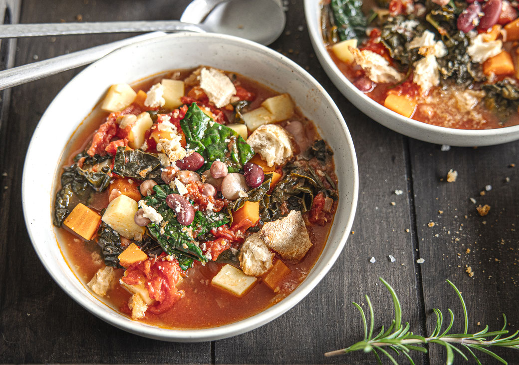 Toskanische Ribollita mit Palmkohl, weißen Bohnen und geröstetem Ciabatta - herzhafte, mediterrane Suppe in Schale serviert.