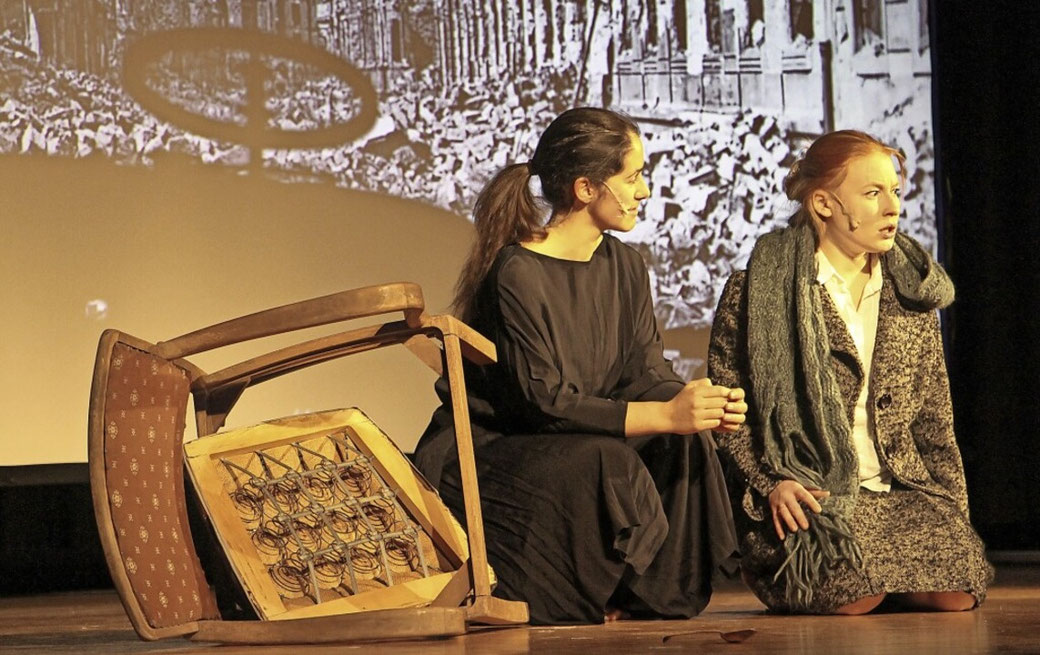 Traudl (Giulia Doreen Artéman, rechts) bricht zusammen angesichts des unermesslichen Kriegsleids, Sophie (Jeanne Zaugg) hindert sie am Selbstmord. Foto: Ruth Seitz