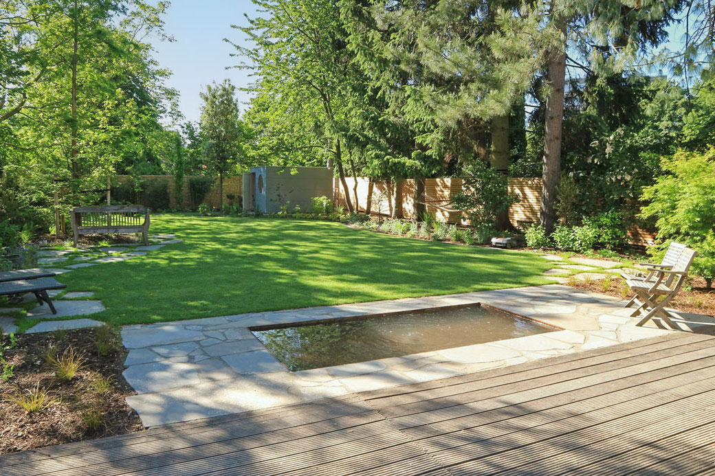 Terrasse mit angrenzendem Wasserbecken und Garten