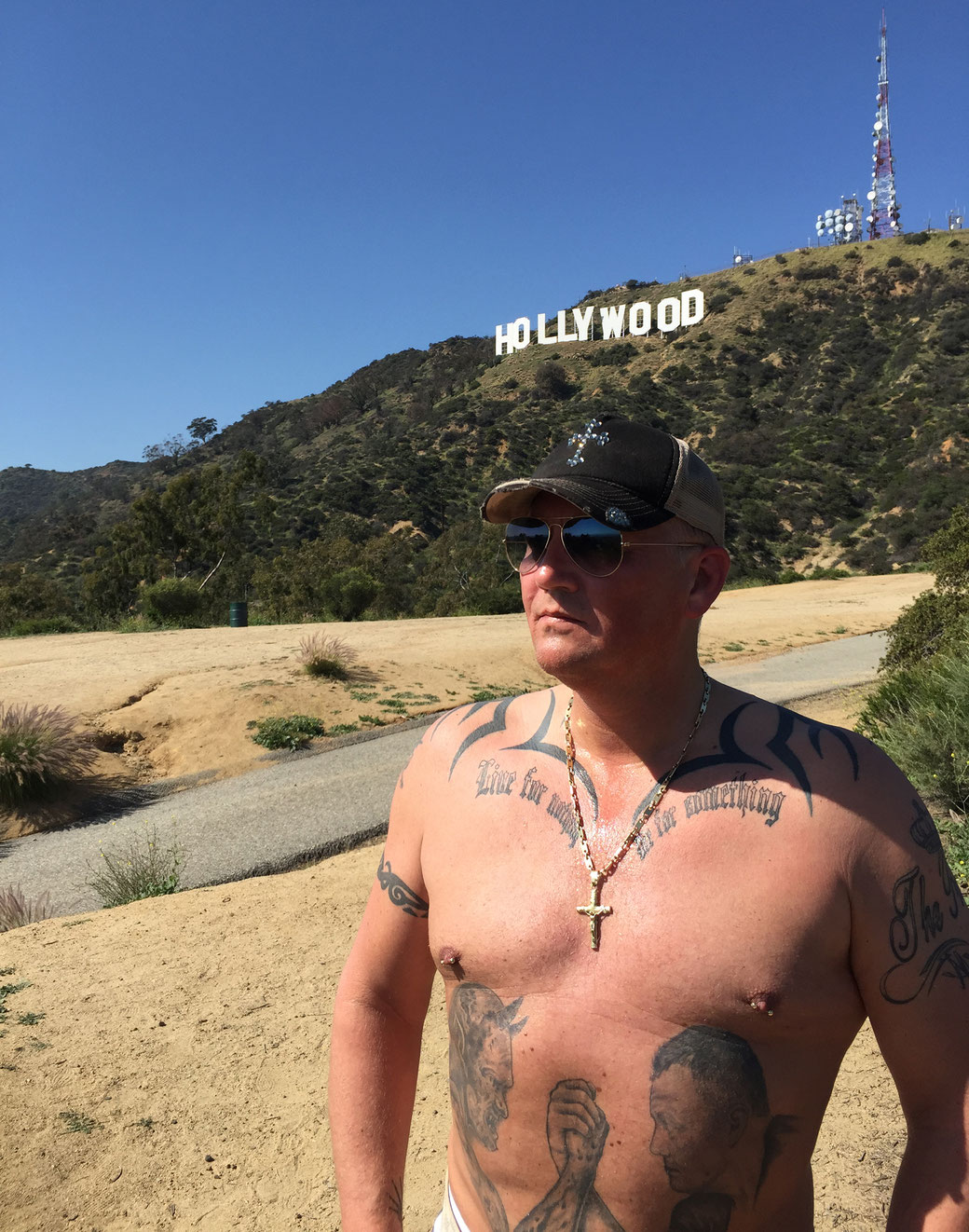 Hier sehen Sie Prinz Alexander von Anhalt mit nacktem Oberkörper und seinen Tattoos vor dem berühmten Hollywood Sign in Los Angeles - Kalifornien