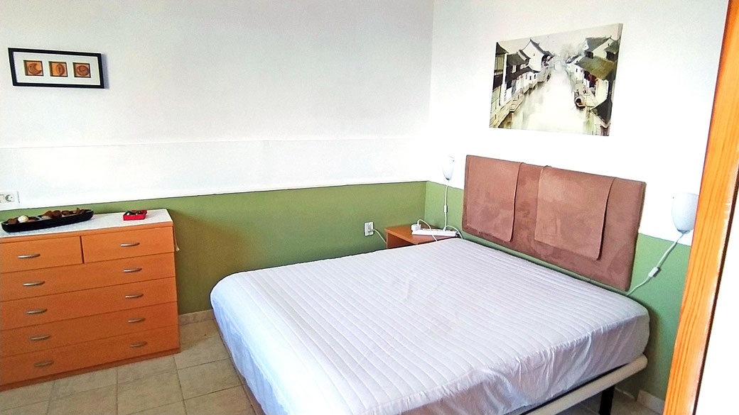 Das Schlafzimmer mit Doppelbett (150 cm) und Zugang zum Bad