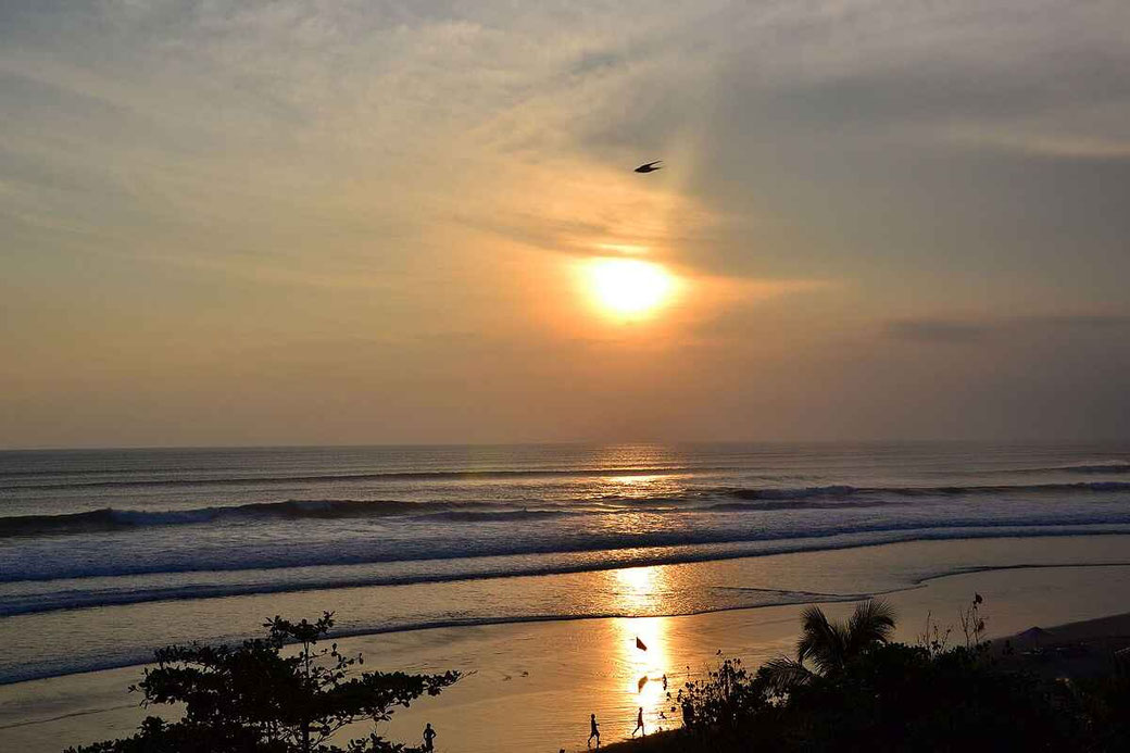 Gouden zonsondergang boven het strand van Seminyak en de Indische Oceaan.