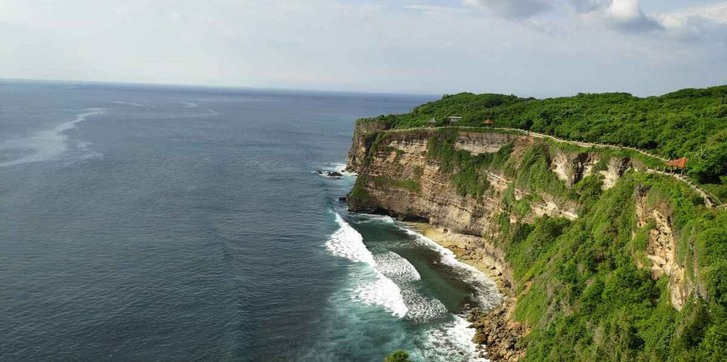 Dramatische Kalksteinklippen mit dem malerischen Weg zum heiligen Uluwatu-Tempel.