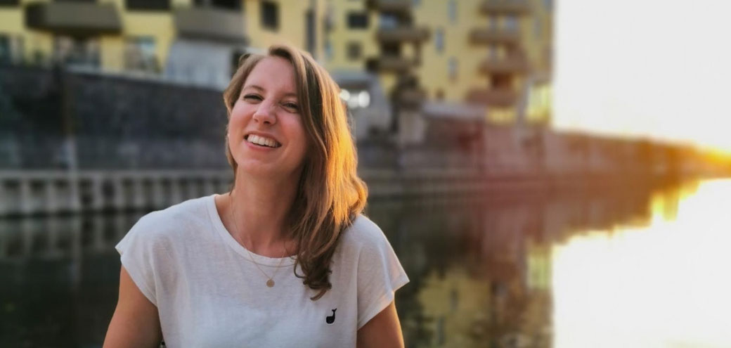 Lachende Frau, Maxine Morast in die Kamera blickend mit Sonnenuntergang im Hintergrund