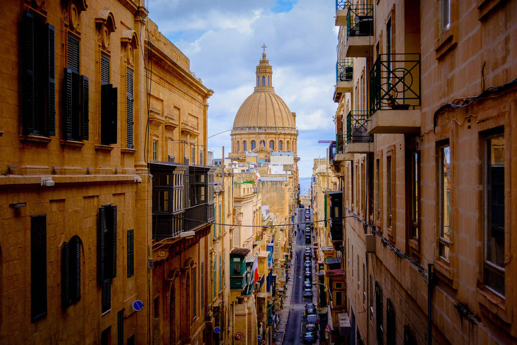 Strassenschlucht in Valletta mit großer Kuppel einer Kirche