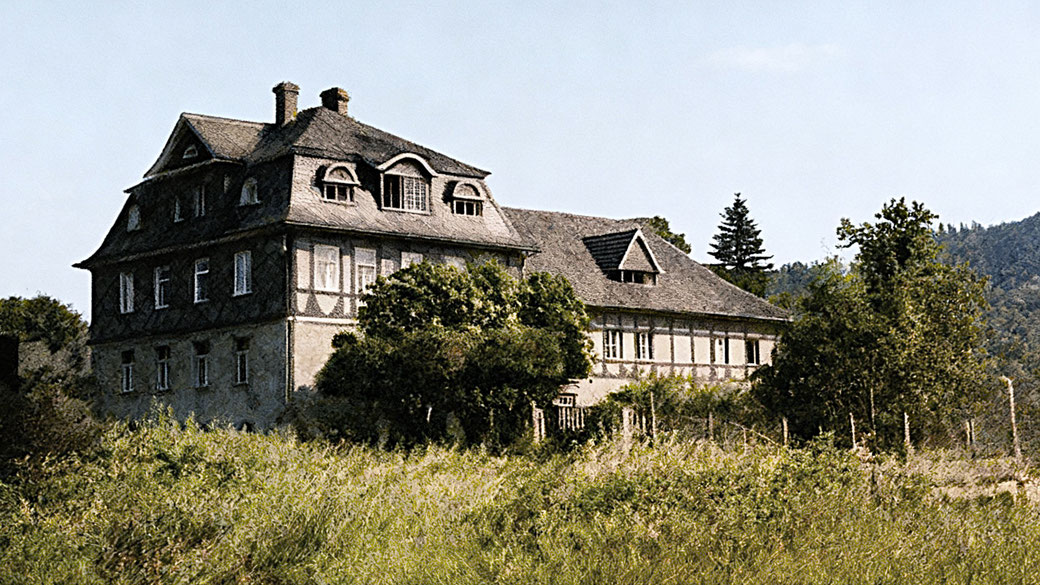 Nach Brand wieder neu aufgebaut: Wohnhaus mit Pension. Angrenzend Stall und Scheune. (SW-Foto um 1950 koloriert)