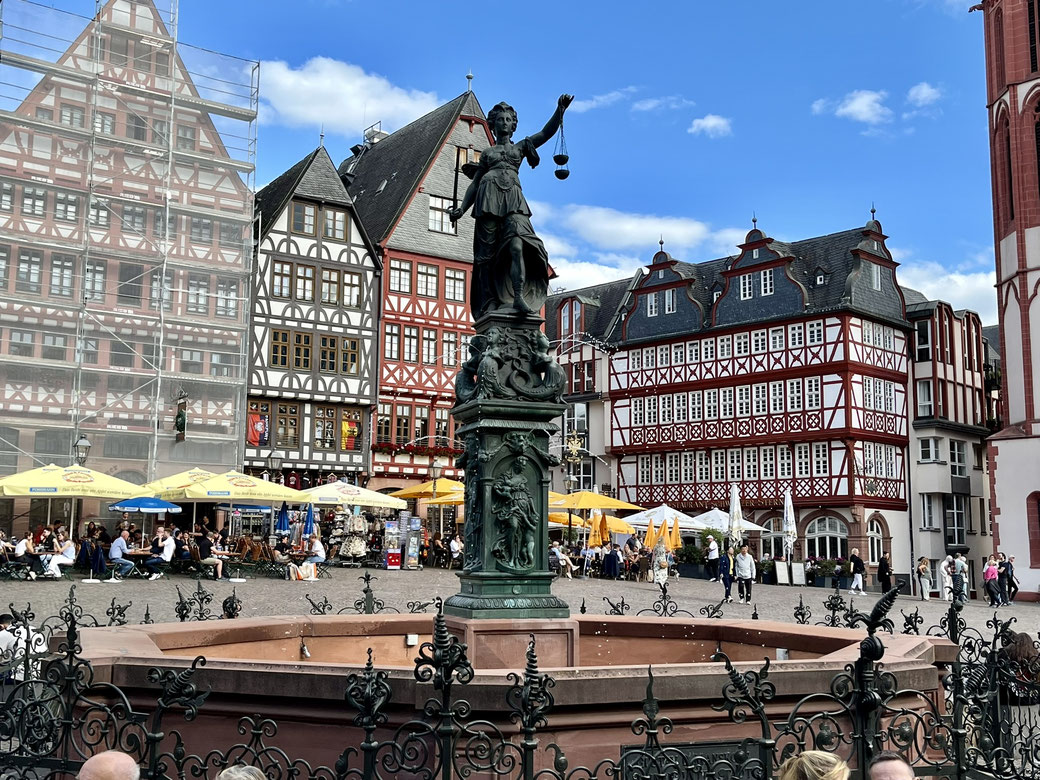 Am Römer: Der Gerechtigkeitsbrunnen mit Justitia. Im Hintergrund historische Markthäuser mit reichem Fachwerk-Schmuck