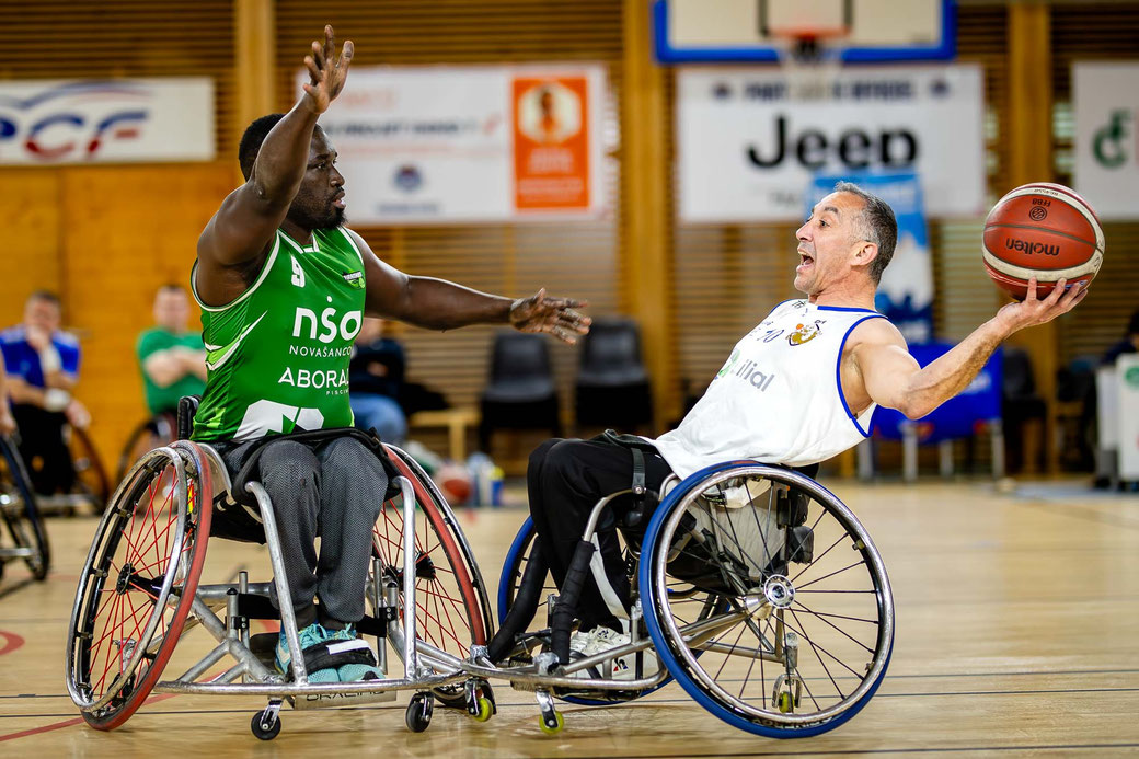 Photographe handisport à Montauban lors d’un match de basket fauteuil avec un joueur en train de tirer face à un défenseur