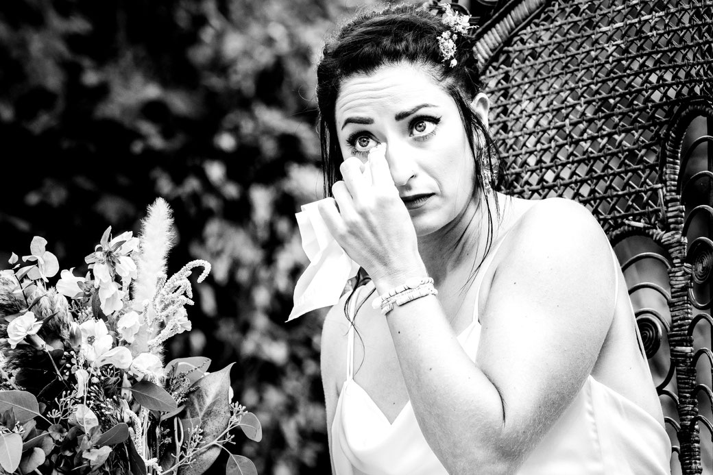 Mariée émue pendant les discours lors d’un mariage photographié en noir et blanc par Cyril Langeard