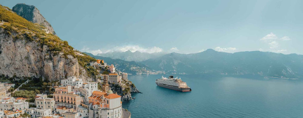 Explora Journeys Kreuzfahrtschiff vor der Amalfiküste mit Blick auf die malerische Küstenlandschaft Italiens