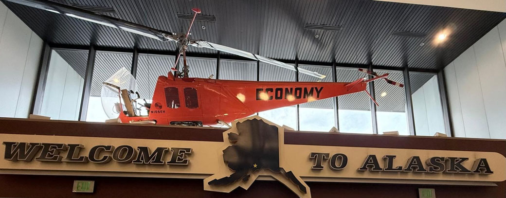 Willkommensschild mit dem orangefarbenen Hubschrauber befindet sich im Ted Stevens Anchorage International Airport in Alaska