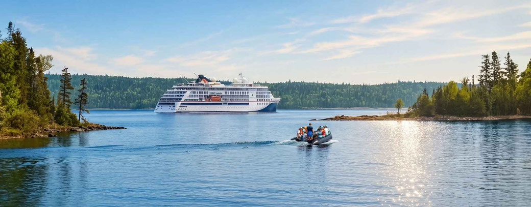 Ein Schiff von Hapag-Lloyd Cruises auf dem Meer mit einem Zodiacboot im Vordergrund