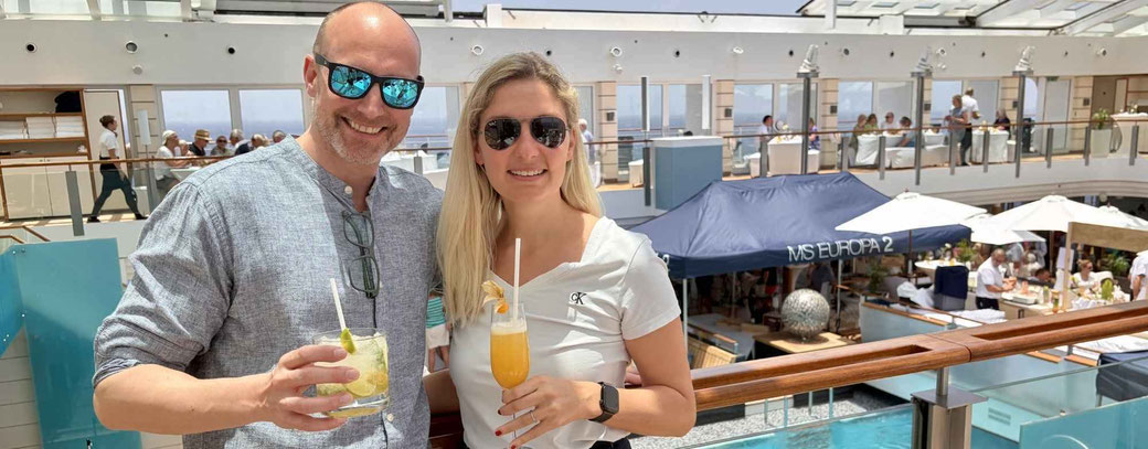 Zwei Gäste auf der MS EUROPA 2 mit Drinks in den Händen