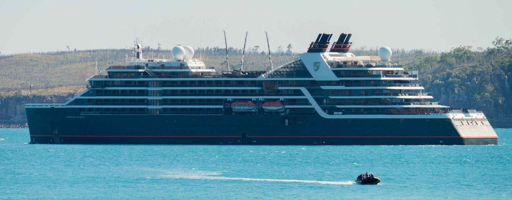 Seabourn Pursuit vor einer Küste mit Zodiacbook im Vordergrund