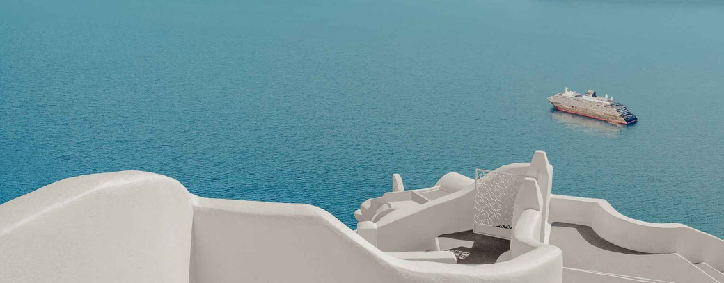 Kreuzfahrtschiff vor den weißen Häusern und dem azurblauen Meer von Santorin in der Ägäis