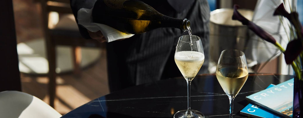 Champagner wird stilvoll in Gläser eingeschenkt – luxuriöses Ambiente an Bord der Crystal Symphony
