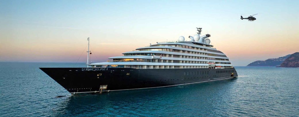Scenic Eclipse II vor einer Bucht mit Hubschrauber im Anflug