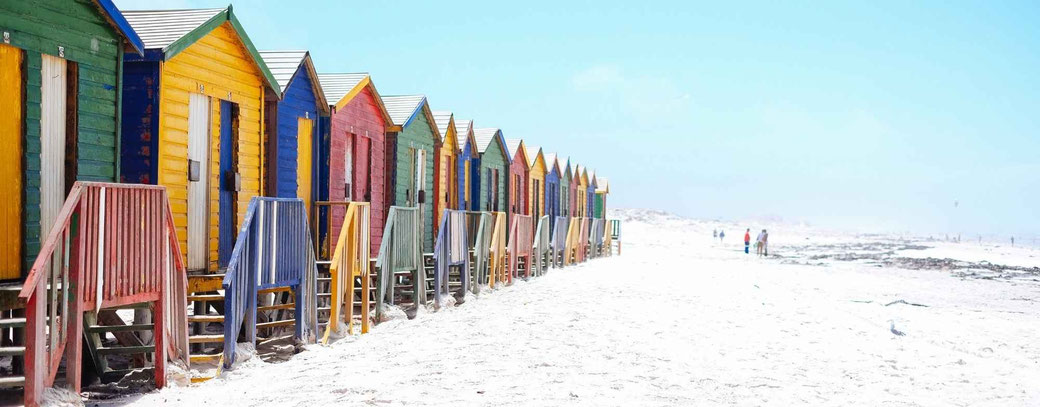 Bunte Holzhütten in Muizenberg in Kapstadt mit weißem Sand