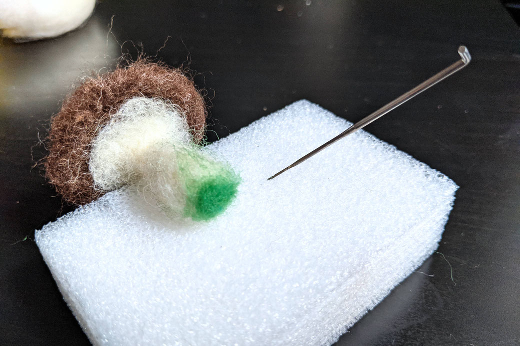 Felted mushroom on foam block, showing bottom where green wool is added