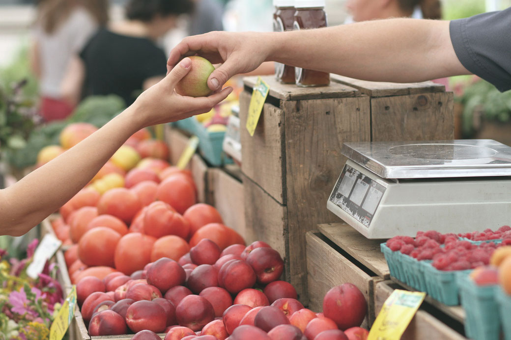 Apples and produce for sale at farmers market.