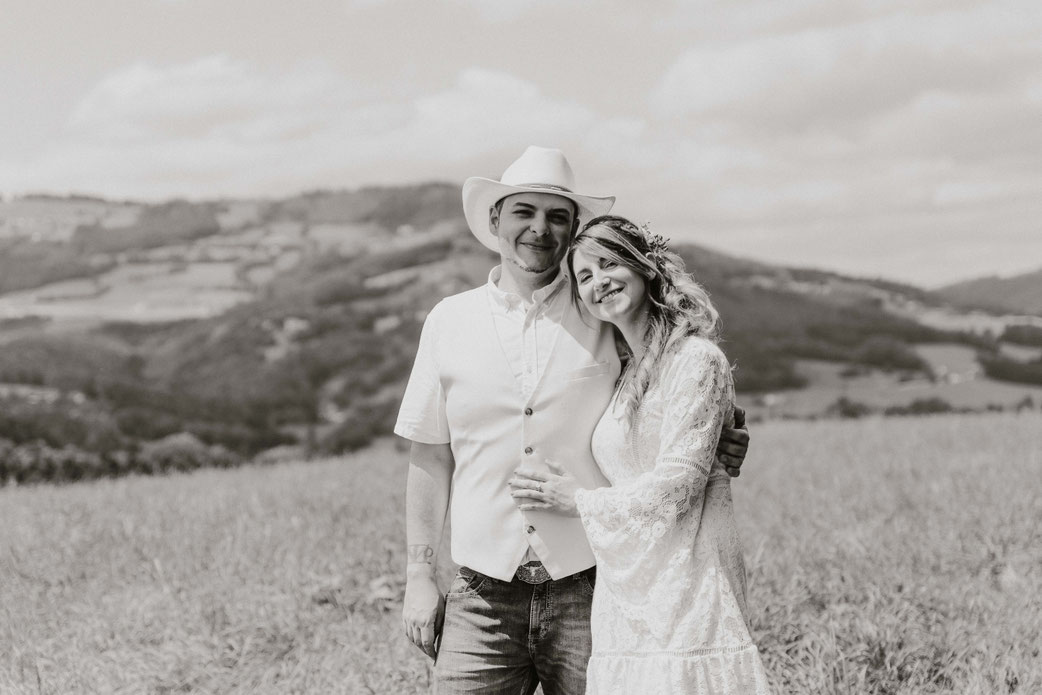 Ein Brautpaar lächelt in die Camera bei einem Verlobungsshooting bei einer professionellen Hochzeitsfotografin in der Pfalz.