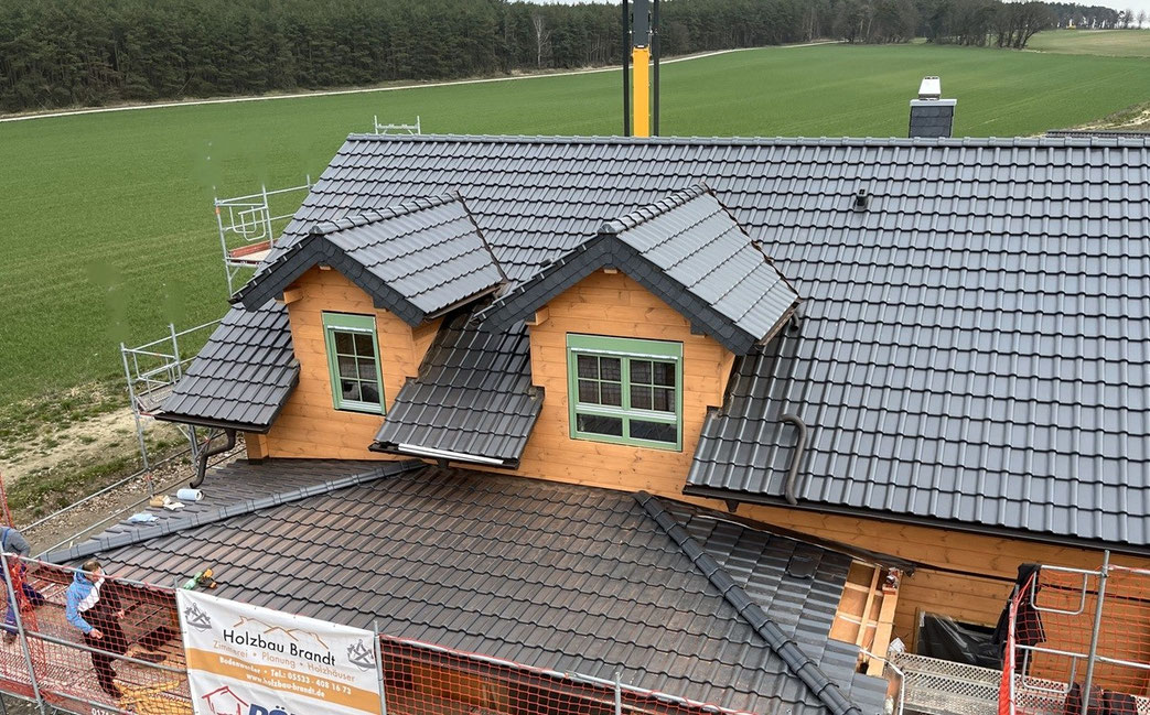 Blockhausbaustelle – Blockhausbau – Dachkonstruktion mit Aufdachdämmung – Montage von Dacheindeckung, Dachrinnen und Fallrohre – Holzbau Wolfgang Brandt