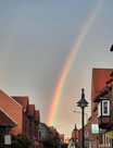 Die linke Seite eines kräftigen Regenbogens über einer Straße im Ort Dannenberg