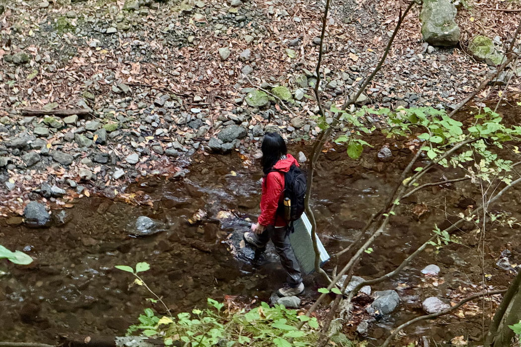 沢を渡る女性。一人で森を感じながらゆっくり歩く時間。