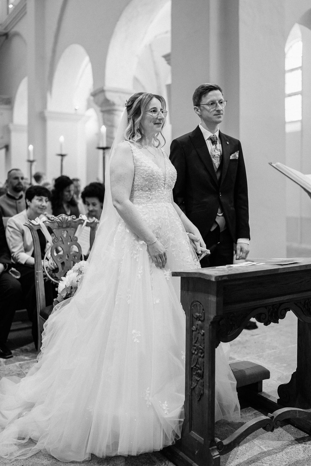 Blick von der Seite: Die Pfarrerin spricht zum Brautpaar vor dem Altar.