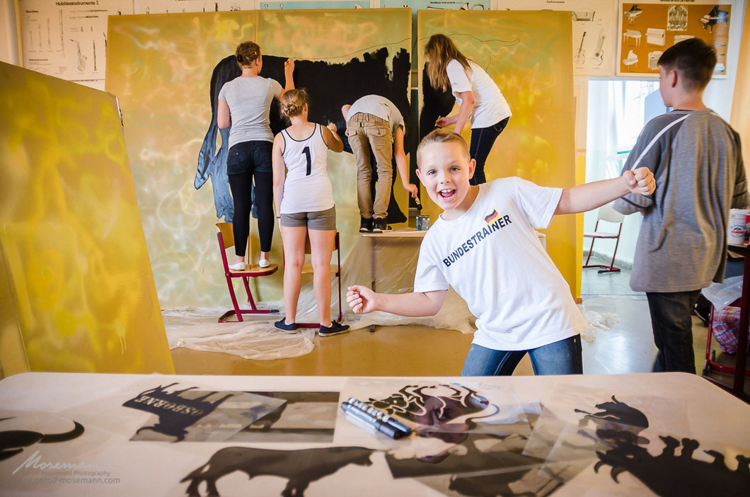 Kids painting the scenery for the opera Carmen