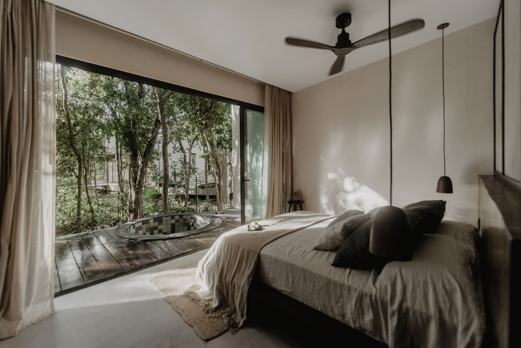 Habitación principal con vistas a la naturaleza, en un proyecto residencial con diseño bioclimático en Tulum, México.