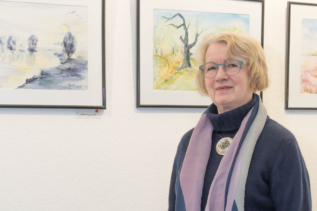 Gudrun Wege vor ihren Aquarellen im Mehrzweckraum Zühlsdorf
