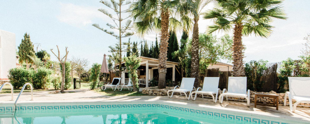 pool with sunbeds and palmtrees in spain