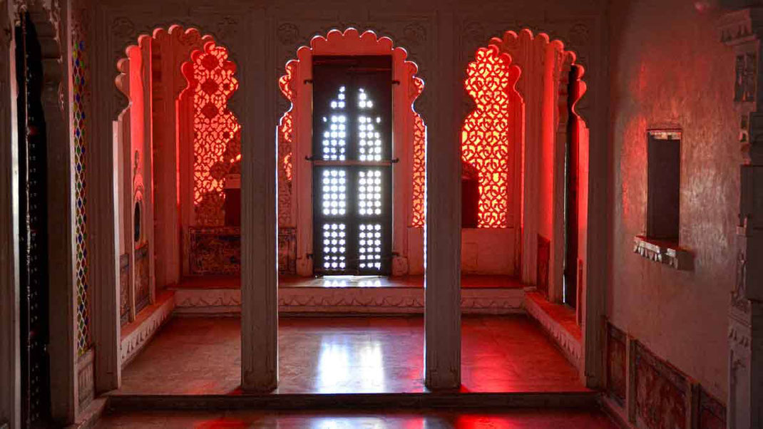 Une petite pièce du fort d'Udaipur protégée du soleil par un claustra enrichi de verres teintés rouges.