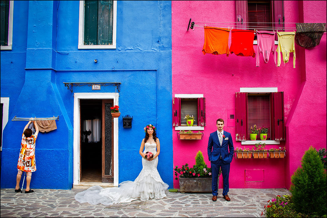 Hochzeitspaar vor einem bunten Haus in Burano