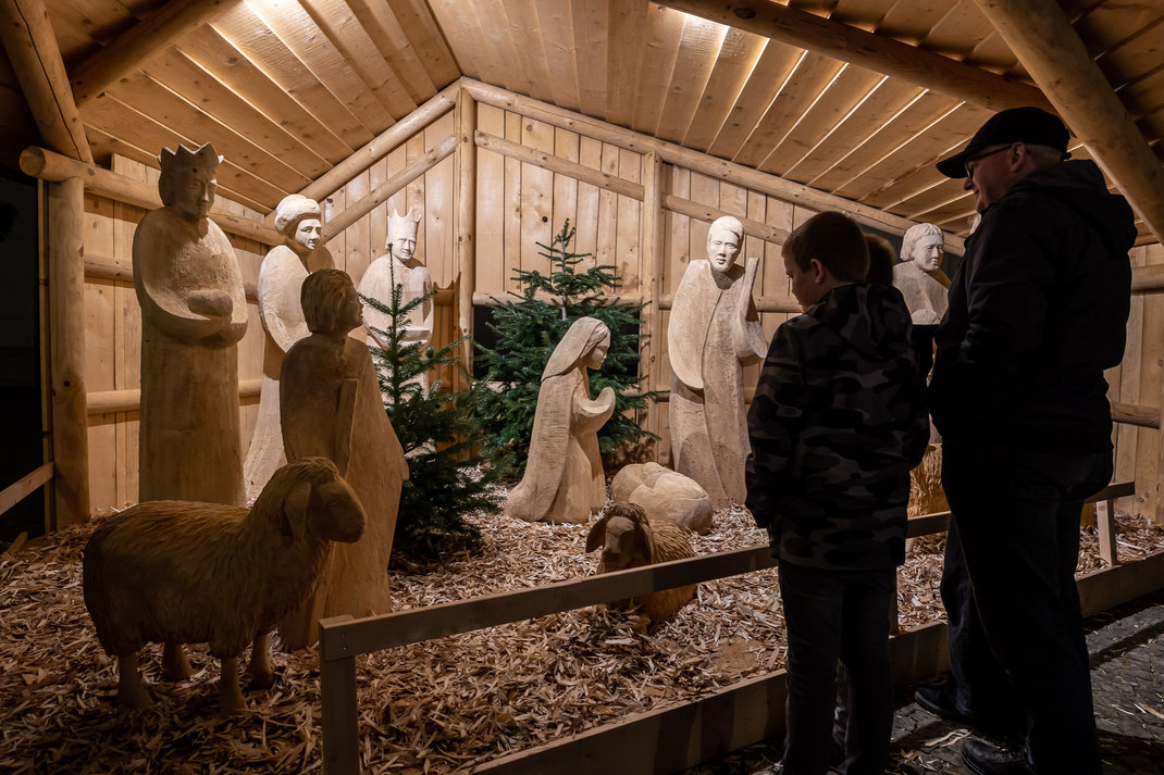 Die Weihnachtskrippe mit den lebensgrossen Holzfiguren vor der Kirche.