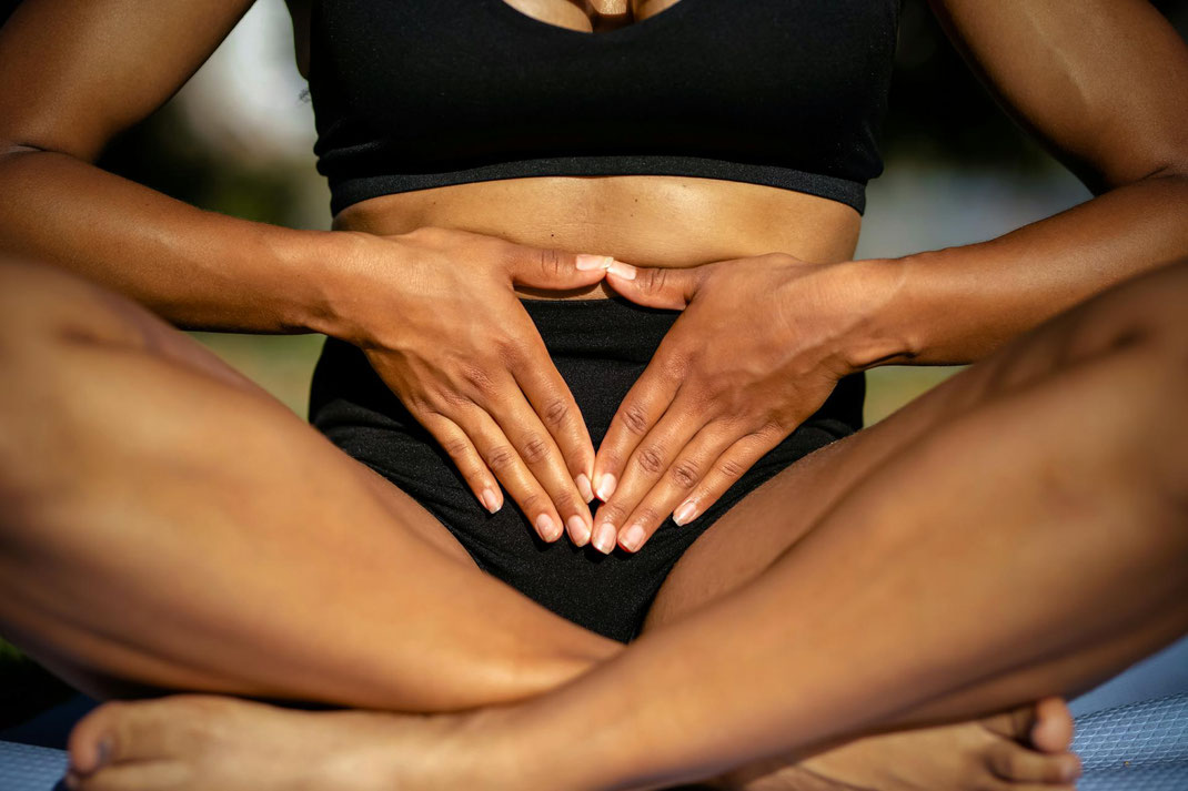 Sportliche Frau fasst ganz bewusst ihren Bauch an