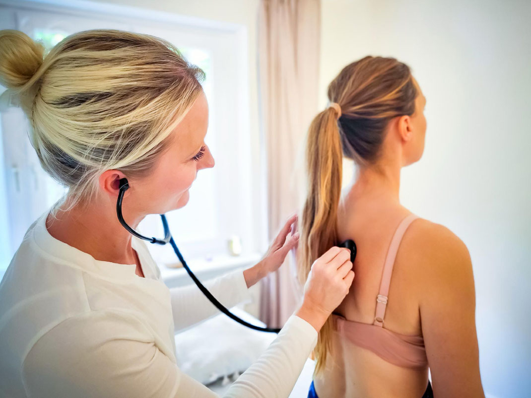 Anne-Kathrin Harders hört einer Patientin mit dem Stethoskop die Lunge ab