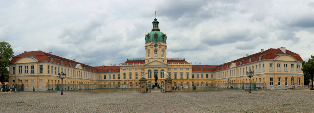 Sehenswürdigkeiten Berlin: Ansicht des Schlosses von der Straße Spandauer Damm aus. Die Kuppel des herrschaftlichen Schlosses überragt den Haupttrakt und die beiden Seitenarme des Schlosses.