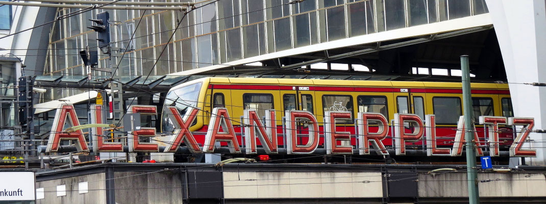 Sehenswürdigkeiten Berlin: Ein gelb-rot gestrichener Zug fährt in den Bahnhof «Alexanderplatz» ein. Der Bahnhof zählt zu den wichtigsten Bahnhöfen der Stadt. Er wurde 1982 eröffnet.