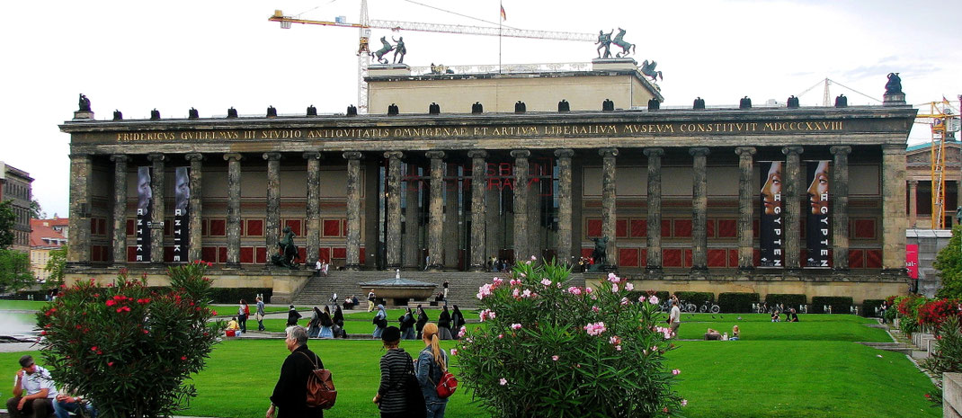Sehenswürdigkeiten Berlin: Das «Alte Museum» am Lustgarten beeindruckt mit seinen vielen ionischen Säulen, den kunstvollen Bronzestatuen und den Werbeflaggen, welche die hochkarätigen Ausstellungen bewerben.