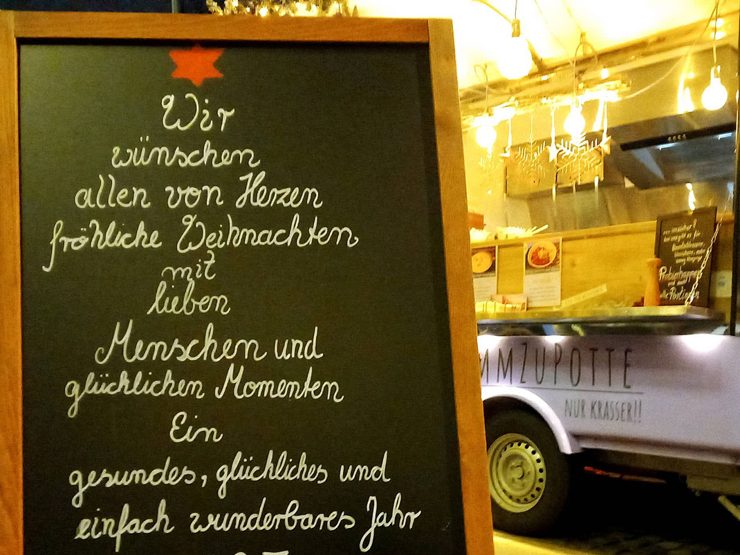 Schild mit guten Weihnachtswünschen vom KommZuPotte Winter Foodtruck