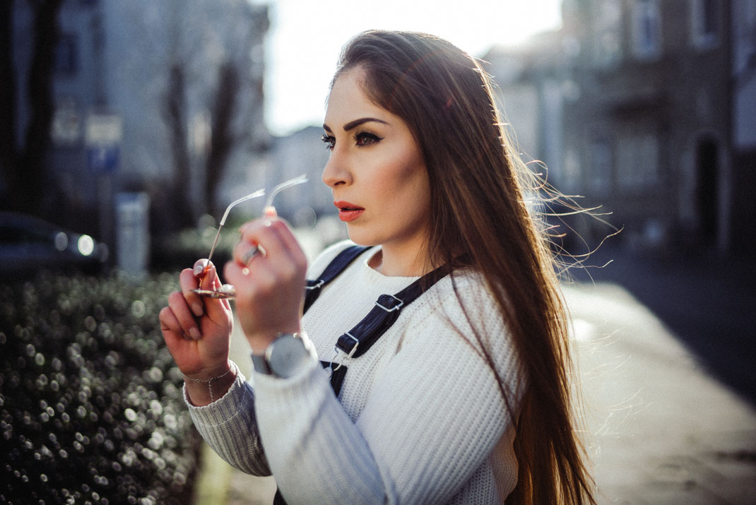 Stylische junge Frau mit Sonnenbrille in der Hand