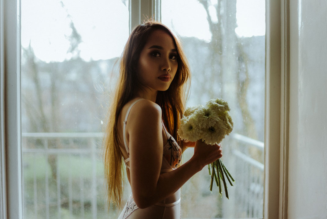 Frau in Dessous mit Blumen in der Hand
