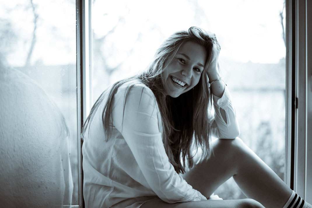 Junge Frau lacht herzhaft in die Kamera Fotoshooting Oldenburg